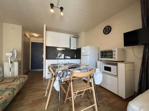 une cuisine avec une table et des chaises dans une pièce dans l'établissement Studio avec Loggia et Parking Privatif - Cap d'Agde - FR-1-249-442, au Cap d'Agde