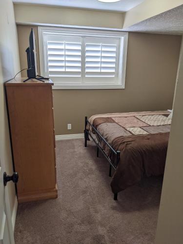 a bedroom with a bed and a television and a window at Beautiful Large Residential Home in Layton