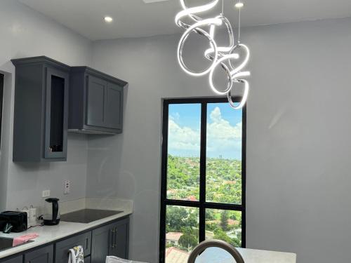 a kitchen with a chandelier in front of a window at Hillside Haven in Kingston