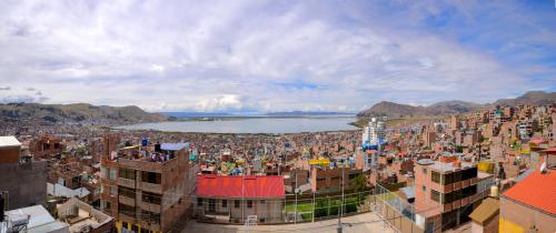 a large city with a body of water and buildings at REFUGIO PANORAMICO EN PUNO 3 Niveles con Vista al Lago Titicaca y la Ciudad in Puno