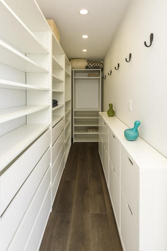a walk in closet with white cabinets and wood floors at Trendy Downtown Loft Apartment - King Bed! in Vancouver