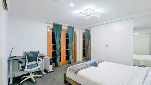 Un dormitorio con una cama, un escritorio y una silla. en Entire Place Private Luxe 1BR with 1BA 1K 1LR, en Ingleburn