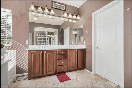 a bathroom with a sink and a large mirror at The Reserve Large Home and Pool in Phoenix