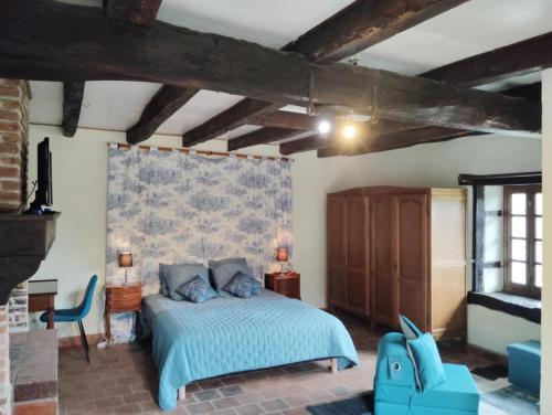 a bedroom with a bed with a blue comforter at Gîte et chambre d'hôtes Les Authentiques in Saint-Estèphe