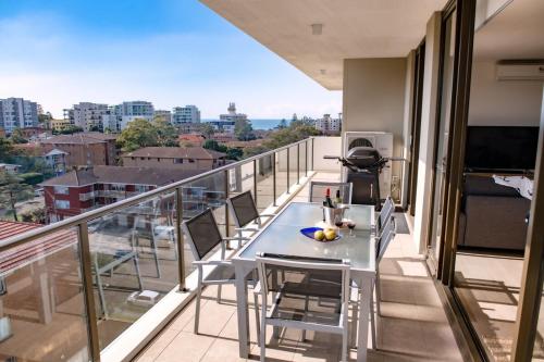 a balcony with a table and chairs on a building at Kembla in Wollongong