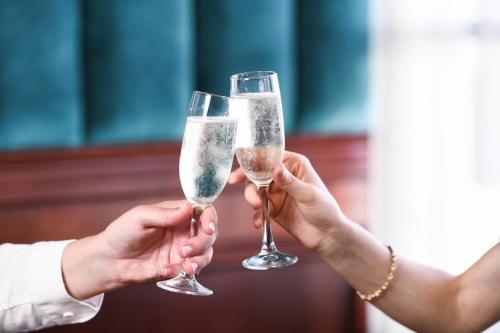two people holding champagne glasses in their hands at Powerhouse Hotel Tamworth by Rydges in Tamworth