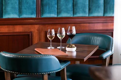 a wooden table with two glasses of wine on it at Powerhouse Hotel Tamworth by Rydges in Tamworth