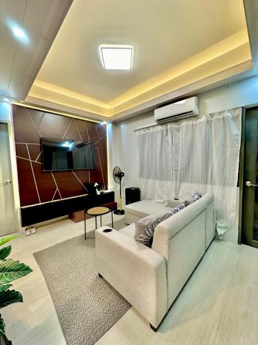 a living room with a couch and a tv at The Calm Nest by Luke and Nian in San Juan