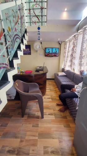 a living room with two people sitting on couches and a table at Hotel Mahamrityunjay Palace in Ujjain