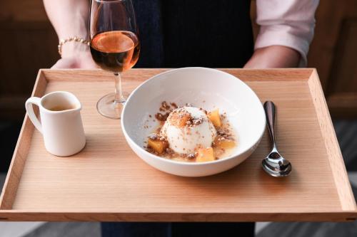 a bowl of food and a glass of wine on a tray at Powerhouse Hotel Tamworth by Rydges in Tamworth