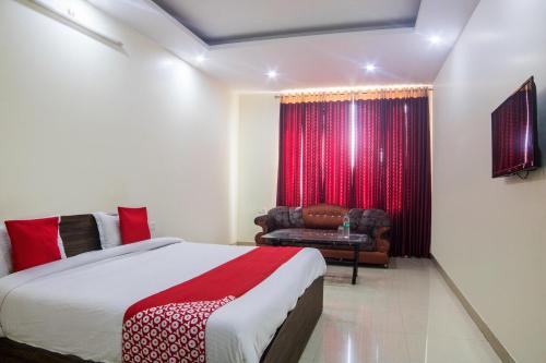 ein Schlafzimmer mit einem Bett und einer Couch und einem Fenster in der Unterkunft Hotel O Shivalaya in Haldwani-Kathgodam