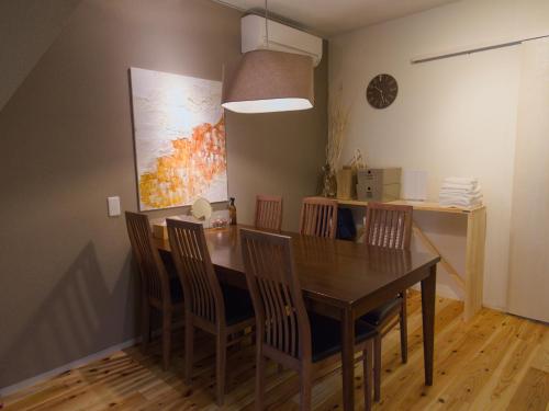 a dining room with a wooden table and chairs at Forest Japandi House in Osaka