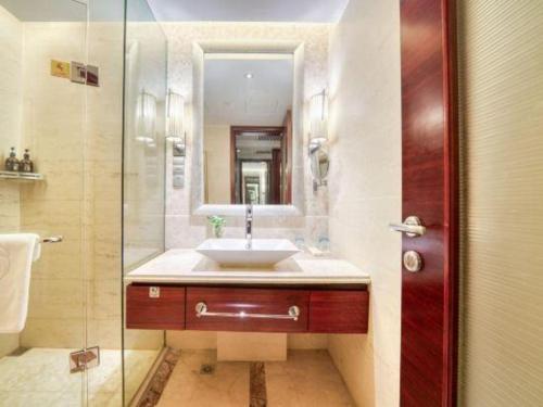 a bathroom with a sink and a glass shower at Xiangsheng Century Hotel Zhuji in Shaoxing