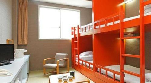 a room with two bunk beds with a desk and a computer at Hotel SP Haruno in Kochi