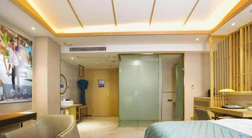 a hotel room with a bed and a desk and a bathroom at Quanzhou Binhai Hotel in Quanzhou