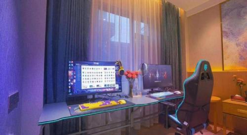 a desk with a computer and a chair in a room at Quanzhou Binhai Hotel in Quanzhou