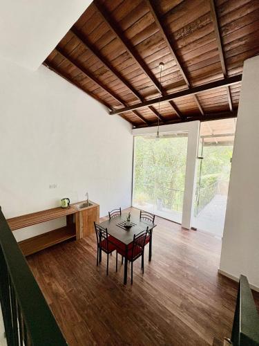 a room with a table and chairs and a large window at Coz Haven Ella in Ella