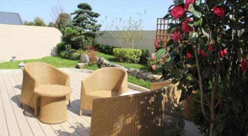 two wicker chairs and a table in a garden at Xian Elegant Oriental Hotel in Xi'an