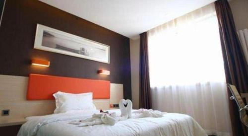 a hotel room with a bed with towels on it at 7 Days Premium Beijing Dabaotai Metro Station Luhua Road in Beijing