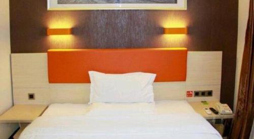 a bed with an orange headboard in a room at 7 Days Premium Beijing Dabaotai Metro Station Luhua Road in Beijing