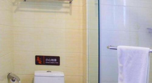 a bathroom with a toilet and a shower with a towel at 7 Days Premium Beijing Dabaotai Metro Station Luhua Road in Beijing