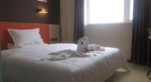 a swan decoration on a bed in a bedroom at 7 Days Premium Beijing Dabaotai Metro Station Luhua Road in Beijing