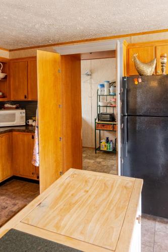 a kitchen with a wooden table and a refrigerator at Flatt Creek Cottage in Livingston