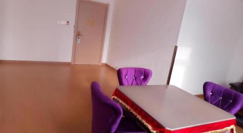 a meeting room with purple chairs and a table at GreenTree Inn Shangrao Qianshan hekou old town Xinjiang longting shell hotel in Shangrao