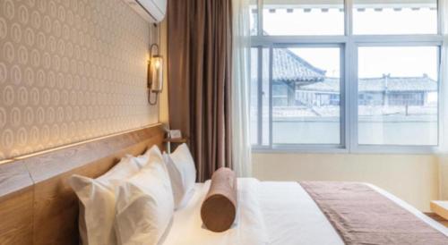 a hotel room with a bed with a window at James Joyce Coffetel Qufu Tourist Center Gulou Street Sankong Scenic Spot in Jining