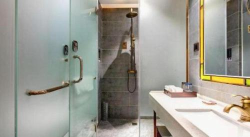 a bathroom with a shower with a sink and a shower at James Joyce Coffetel Qufu Tourist Center Gulou Street Sankong Scenic Spot in Jining