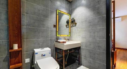 a bathroom with a sink and a toilet and a mirror at James Joyce Coffetel Qufu Tourist Center Gulou Street Sankong Scenic Spot in Jining
