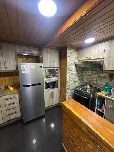 a kitchen with a refrigerator and a stove at Casa amoblada 7 personas in Padre Las Casas