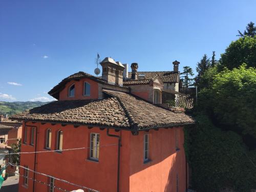 a red building with a tower on top of it at Castelbourg in Neive