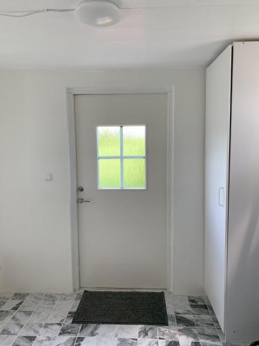a white room with a door and a window at Flähult 107B in Ullared