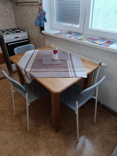 a wooden table with two chairs and a napkin on it at Prázdninové ubytování - celý byt jen Váš in Litomyšl