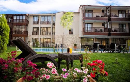 a building with a yard with a table and flowers at Venus Suite Hotel in Pamukkale