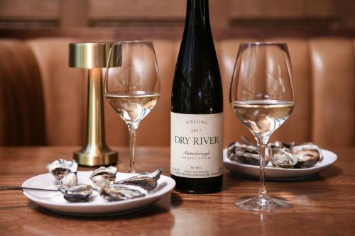 a bottle of wine and two wine glasses on a table at Powerhouse Hotel Tamworth by Rydges in Tamworth