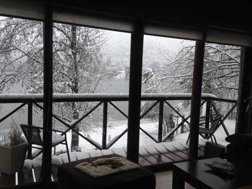 a window with a view of a snow covered yard at Orillas del Gutierrez in San Carlos de Bariloche