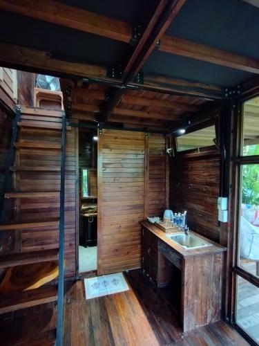 a kitchen with a sink and wooden walls at Xóm Sình Homestay & Farmstay Buôn Ma Thuột ĐakLak in Ðat Lý (1)
