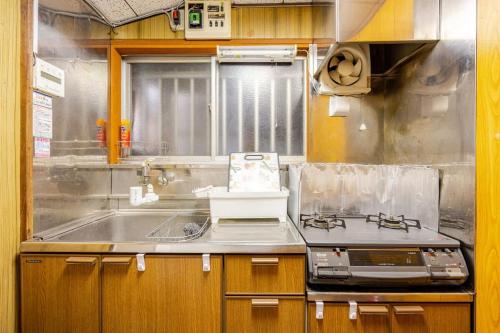 eine Küche mit Spüle und Herd in der Unterkunft 東新小岩5丁目 in Tokio