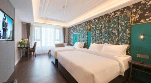 a hotel room with two beds and a green wall at James Joyce Coffetel Harbin West High-speed Railway Station Wanda Plaza in Harbin