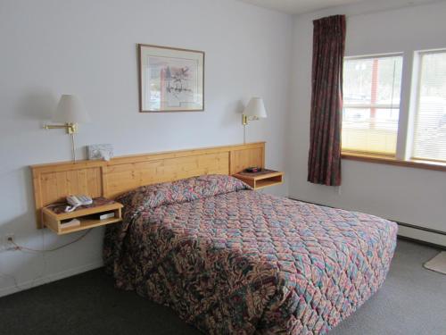 a hotel room with a bed and a window at Bonanza Gold Motel in Dawson City