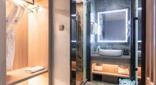 a bathroom with a sink and a mirror at Han Hotel Meisu Xi'an Longshouyuan Shenglong Plaza in Xi'an