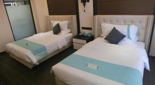 a hotel room with two beds and a mirror at Xana Hotelle Xi'an Zhonglou, Huimin Street Metro Station in Xi'an