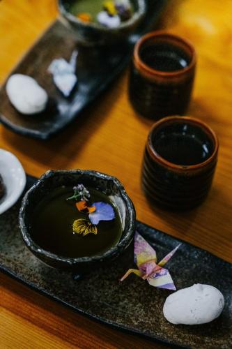 a table with a plate with a bowl with a bird on it at Shizuka Ryokan Japanese Country Spa & Wellness Retreat in Hepburn Springs