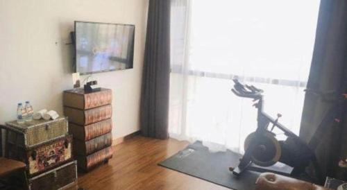 a living room with a treadmill and a flat screen tv at James Joyce Coffetel Guilin Railway Station Xiangbi Mountain Liangjiang Sihu Wharf in Guilin