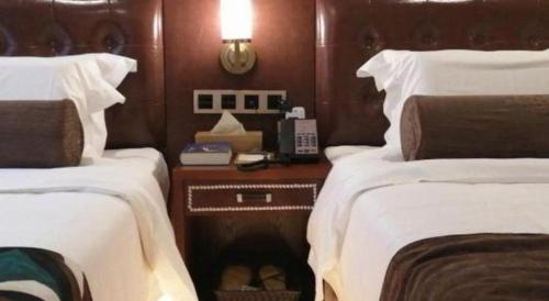 a bedroom with two beds and a phone on a table at James Joyce Coffetel Guilin Railway Station Xiangbi Mountain Liangjiang Sihu Wharf in Guilin