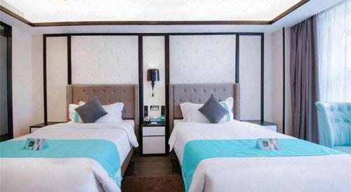 two beds in a room with blue and white at Xana Hotelle Jinan Wuanfu Interchange Huafu International Square in Jinan