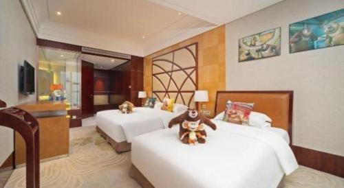 a bedroom with two beds with teddy bears on them at Balan International Hotel in Dujiangyan