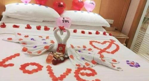a bed with hearts painted on the sheets at Vienna Hotel Guangdong Huiyang Qiuchang Yingbin Road in Huizhou